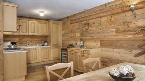 a kitchen with wooden walls and a table and chairs at Chalet Sozzine in Ponte di Legno +45 photos