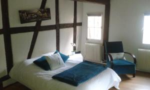 a bedroom with a bed and a blue chair at Appart chaleureux in Colmar