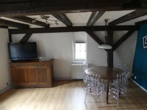 a dining room with a table and a tv at Appart chaleureux in Colmar