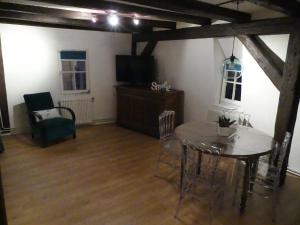 a dining room with a table and chairs and a tv at Appart chaleureux in Colmar +14 photos