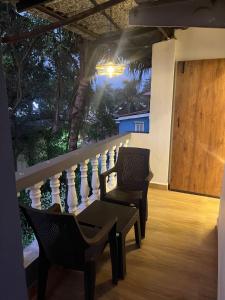 two chairs sitting on a porch with a railing at Aariv Inn BAGA BEACH in Baga