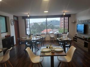 ein Esszimmer mit Tischen und Stühlen und einem großen Fenster in der Unterkunft Hotel Ficoa in Ambato