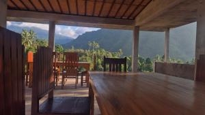 a dining room with a table and a view of the mountains at Sugi Gede Homestay in Singaraja