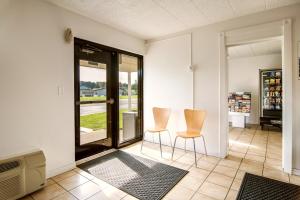 a living room with two chairs and a sliding glass door at Motel 6-New Stanton, PA in New Stanton