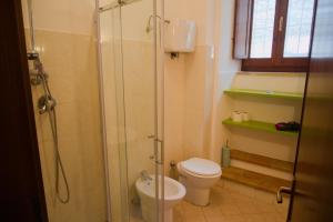 a bathroom with a toilet and a glass shower at Appartamenti Sole alle Torri in Assisi +82 photos