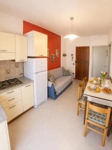 a kitchen and living room with a table and a couch at Condominio Cristina - Agenzia Cocal in Caorle