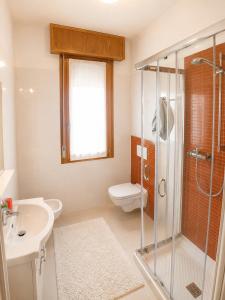 a bathroom with a shower and a toilet and a sink at Condominio Cristina - Agenzia Cocal in Caorle