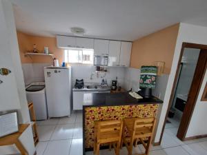 a kitchen with a refrigerator and a table and chairs at Apartamento Enseada Beach Residence completo in Cabo de Santo Agostinho +8 photos