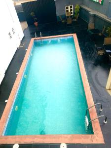 a large pool with blue water in a yard at Bridgewaters Hotel in Abuja +5 photos