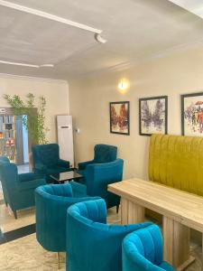 a waiting room with blue chairs and a table at Bridgewaters Hotel in Abuja