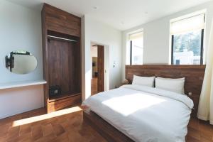 a bedroom with a large white bed and a mirror at Tivoliville Spa N Poolvilla in Pocheon