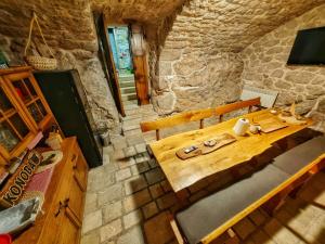 a wooden table and chairs in a stone room at Villa Solaris in Donje Rašćane