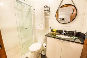 a bathroom with a shower and a toilet and a sink at Apartamento com Café no 1º Dia, Kit Fondue e Aquecedor no Quarto a 300m da Praia para Casais in Imbituba +29 photos
