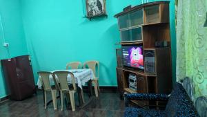 a dining room with a table and chairs and a tv at Villa Estrela Holiday Escape in Betalbatim