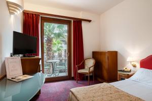 a hotel room with a bed and a sliding glass door at Hotel Catullo in Sirmione