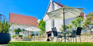 a table and chairs and an umbrella in front of a house at Apartments Dajčić in Varaždinske Toplice