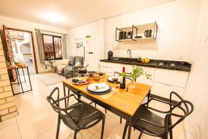 a kitchen and dining room with a table and chairs at Apartamento com Café no 1º Dia, Kit Fondue e Aquecedor no Quarto a 300m da Praia para Casais in Imbituba
