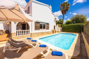a villa with a swimming pool and a house at Villa Ponent in Port d'Addaia