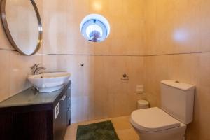 a bathroom with a toilet and a sink and a mirror at Praça da Cultura Residence in Buarcos +21 photos