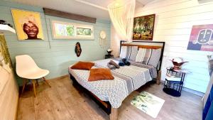 a bedroom with a bed and a chair at Bungalow La Perle - Jacuzzi - Piscine in Saint-François +38 photos