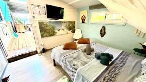 a bedroom with two beds and a large window at Bungalow La Perle - Jacuzzi - Piscine in Saint-François