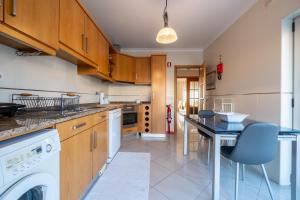 a kitchen with a washer and dryer at Praça da Cultura Residence in Buarcos