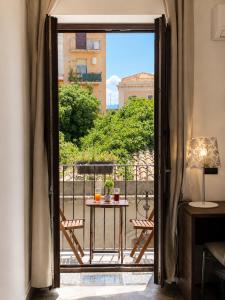 eine offene Tür zu einem Balkon mit Tisch und Stühlen in der Unterkunft Alterego B&B in Milazzo