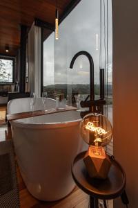 a bath tub in a room with a large window at Studio Sunrise - Luxo, Romance e Natureza in Rancho Queimado +65 photos
