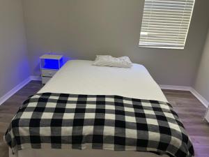 a bed with a black and white checkered blanket on it at Dolphin Room in Tampa
