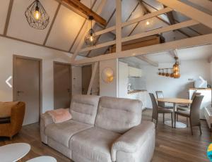 a living room with a couch and a table at Zeevibes - Sunparks - Waterpret - gratis fietsen! in Oostduinkerke