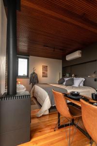 a bedroom with a large bed and a fireplace at Studio Sunrise - Luxo, Romance e Natureza in Rancho Queimado