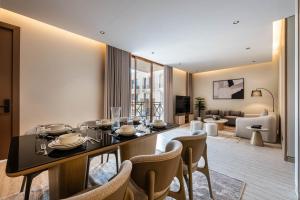a dining room and living room with a table and chairs at Locanda Homes by Jareed لوكاندا هومز باي جريد in Riyadh