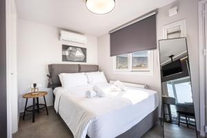 a bedroom with a large bed with white sheets at Glyfadas's Rooftop Blyss in Athens