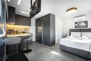 a bedroom with a bed and a desk and a kitchen at Glyfadas's Rooftop Blyss in Athens