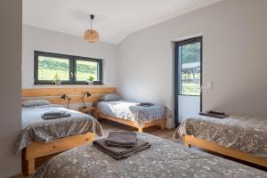 a room with three beds and a window at Dom Przebudzeń in Porąbka