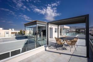 a patio with a table and chairs on a balcony at Glyfadas's Rooftop Blyss in Athens