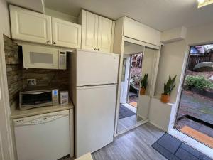 a kitchen with a refrigerator and a microwave at 2-Bedroom Suite in North Vancouver