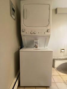 a microwave sitting on top of a refrigerator at 2-Bedroom Suite in North Vancouver +3 photos