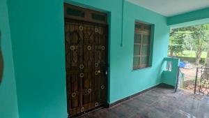 a room with a blue wall and a wooden door at Villa Estrela Holiday Escape in Betalbatim