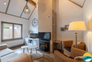a living room with a couch and a fireplace at Zeevibes - Sunparks - Waterpret - gratis fietsen! in Oostduinkerke