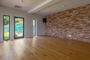 an empty room with a brick wall and wooden floors at Dom Przebudzeń in Porąbka