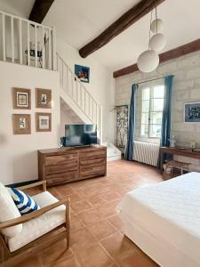 a bedroom with a bed and a tv and a staircase at DOMAINE DES CLOS Hôtel et appartements- Teritoria in Beaucaire