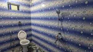 a bathroom with a toilet in a blue wall at Villa Estrela Holiday Escape in Betalbatim