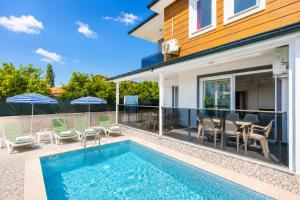 a house with a swimming pool with chairs and umbrellas at Villa Azalea 1 in Ortaca