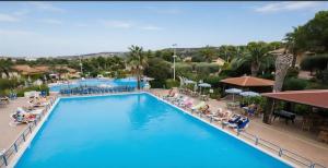 a pool at a resort with people sitting in chairs at Appartamenti Bellavista Club Tropea in Tropea