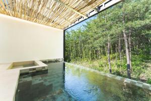 a pool of water in a house with a window at Tivoliville Spa N Poolvilla in Pocheon