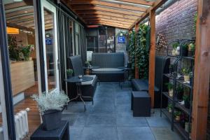 a patio with chairs and tables and a brick wall at Hotel Oepkes in West-Terschelling