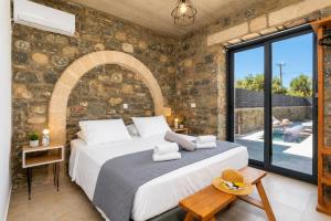 a bedroom with a bed and a stone wall at La Casa Di Pietre 2 in Kiotari +9 photos
