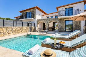 a villa with a swimming pool and a house at La Casa Di Pietre 2 in Kiotari