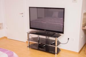 a flat screen tv on a stand in a room at MTM apartment in Bled